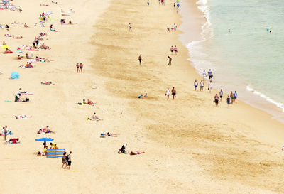 View of people sunbathing on shore