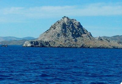 Scenic view of sea and mountains against blue sky