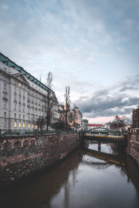 Bridge over river in city against sky