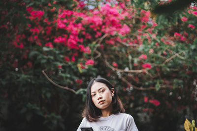 Portrait of young woman against tree