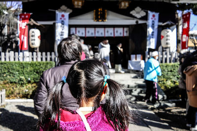 Rear view of girl walking towards temple