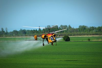 Helicopter flying over agricultural field