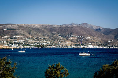 Sailboat sailing on sea against clear blue sky