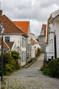 Footpath amidst buildings against sky