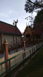 Statues on roof of temple against sky