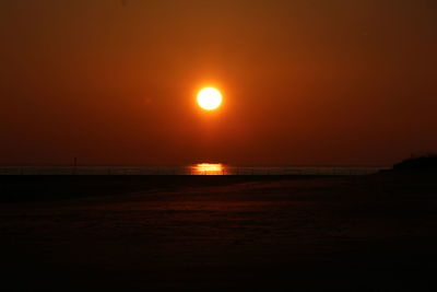 Scenic view of sea against orange sky