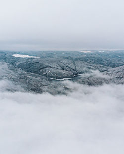 Lake covered by clouds with snow forest around