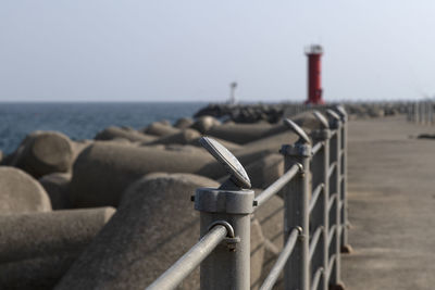 Metal structure on beach against clear sky