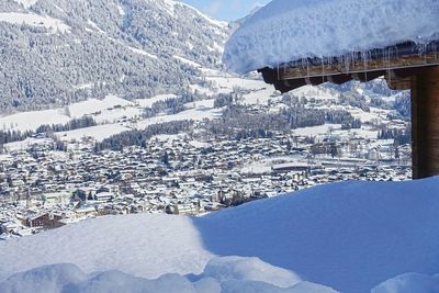 Aerial view of snow covered houses by mountain