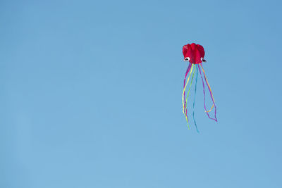 Low angle view of red umbrella against blue sky