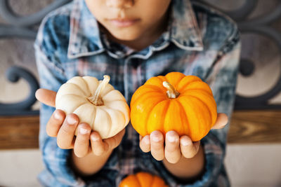 Midsection of man holding pumpkins