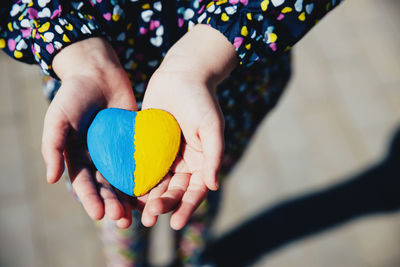 Midsection of woman holding heart shape