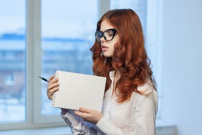 Portrait of young woman holding book