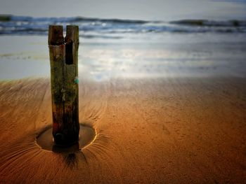 Close-up of water on table at beach against sky