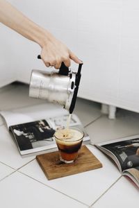 Hand holding coffee cup on table