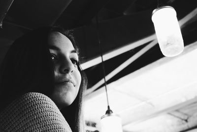 Close-up of young woman against ceiling