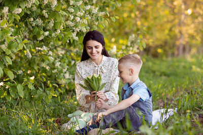 Cute boy with mom on a picnic. son hugs mom