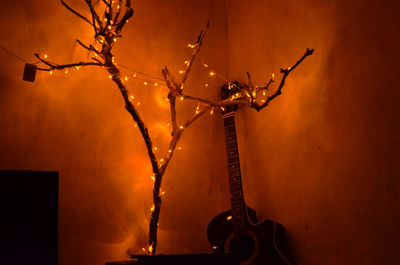 Low angle view of illuminated lighting equipment on wall