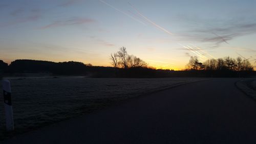 Scenic view of snow covered landscape against sky at sunset