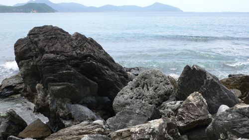 Rocks on sea shore against sky