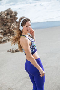 Full length of smiling young woman on beach