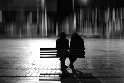 Rear view of man sitting on bench in park