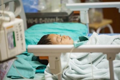 High angle view of cute boy lying on bed in hospital