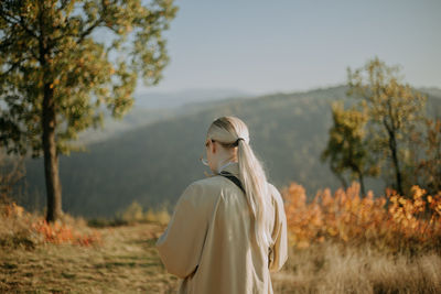 A young woman walking in a field during autumn