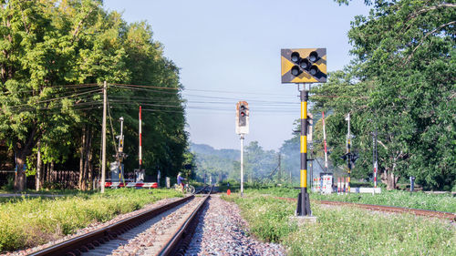 Railroad tracks by trees against sky