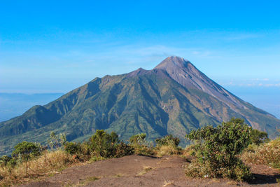 Scenic view of mountains against blue sky