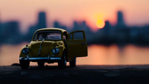 Close-up of toy car against sky during sunset