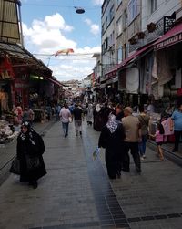 People in market against sky in city