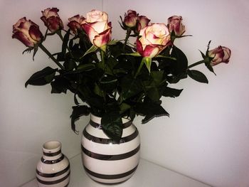 Close-up of roses in vase against wall