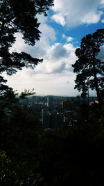 Distant view of city against cloudy sky