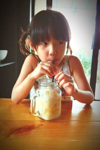 Close-up of girl drinking indoors