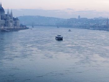 Boats in river with buildings in background