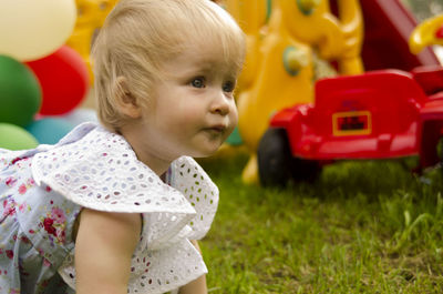 Portrait of cute girl playing with toy on field