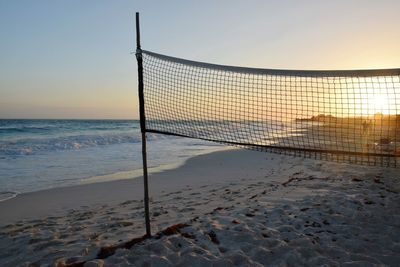 Lifeguard hut on beach against sky during sunset