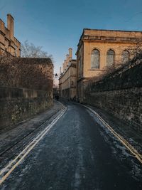 Road amidst buildings against sky