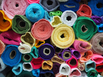 Full frame shot of colorful fabric rolls pile at store