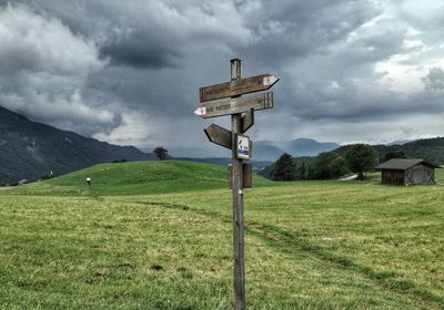 Information sign on grassy field against sky