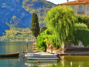 Man standing on jetty by boat moored in lake como