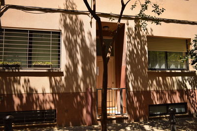 Low angle view of building by tree