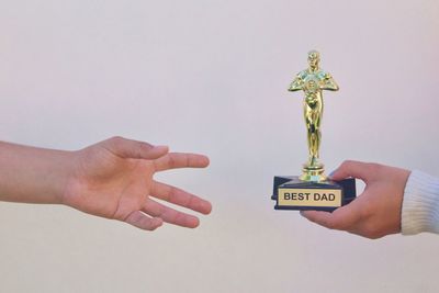 Hand holding cross against gray background