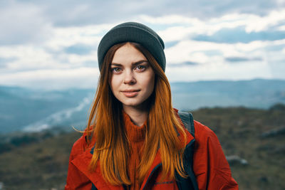 Portrait of young woman wearing hat standing in winter