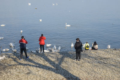 Rear view of people walking on beach