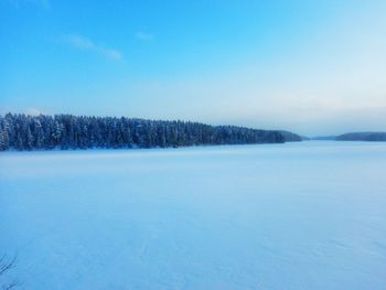 Scenic view of snow covered landscape against clear blue sky