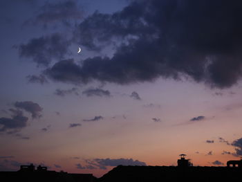 Silhouette buildings against sky at sunset