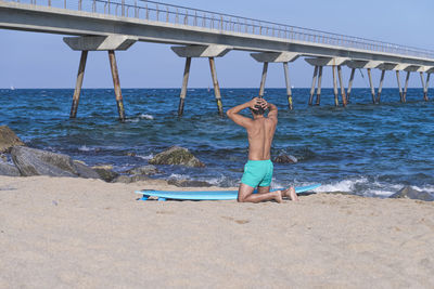 Rear view of woman standing at beach