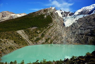 Scenic view of lake by mountains against sky